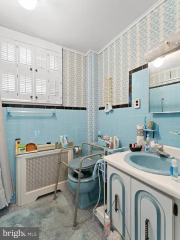a utility room with stainless steel appliances wooden cabinets and a couch
