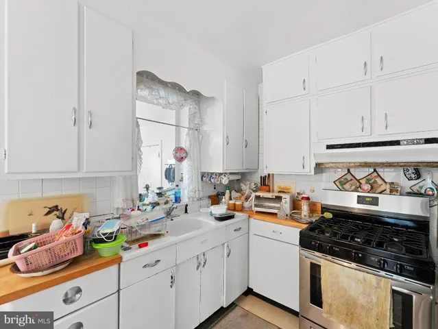 a kitchen with white cabinets and appliances