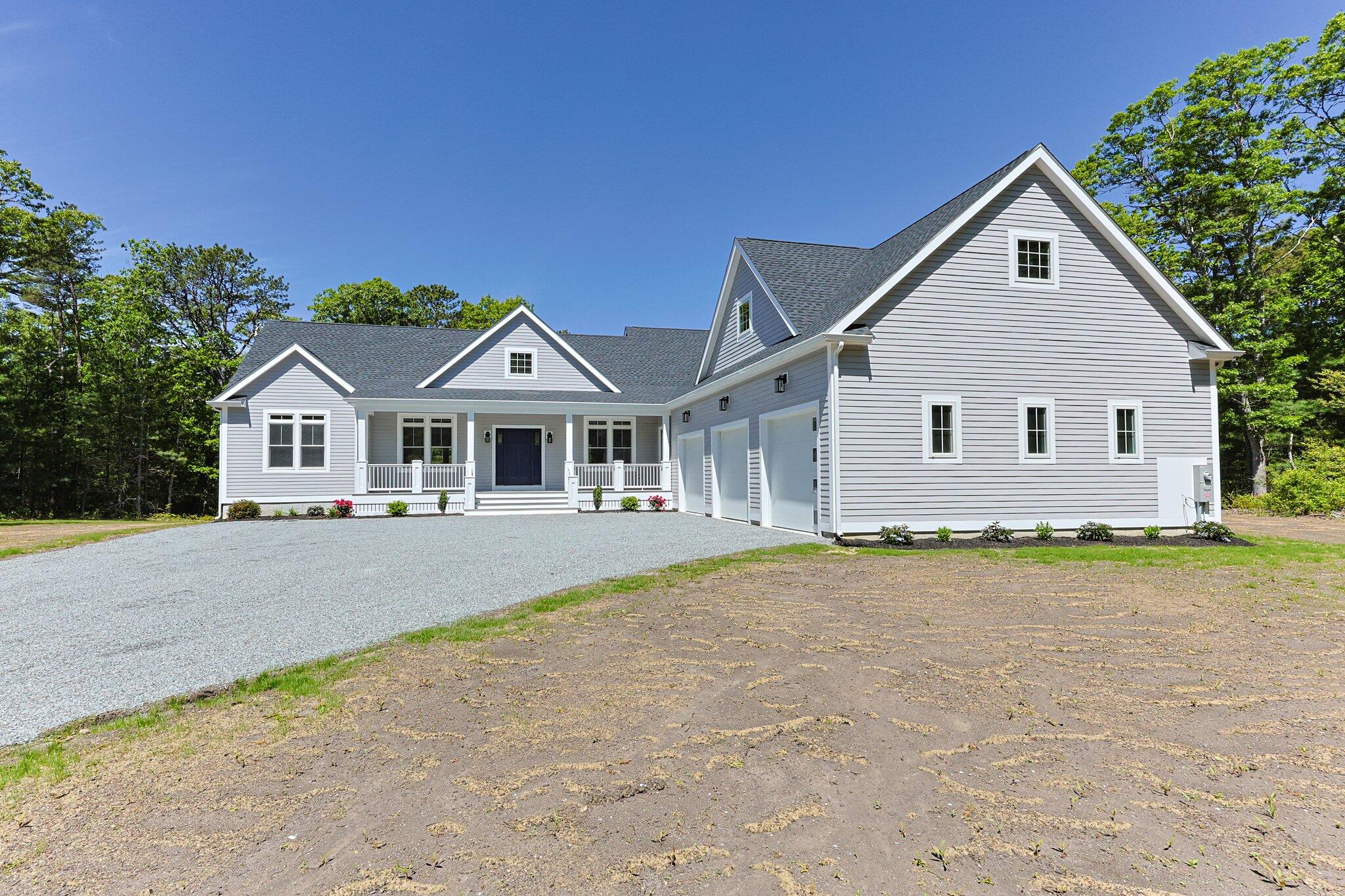 a front view of house with yard and trees in the background