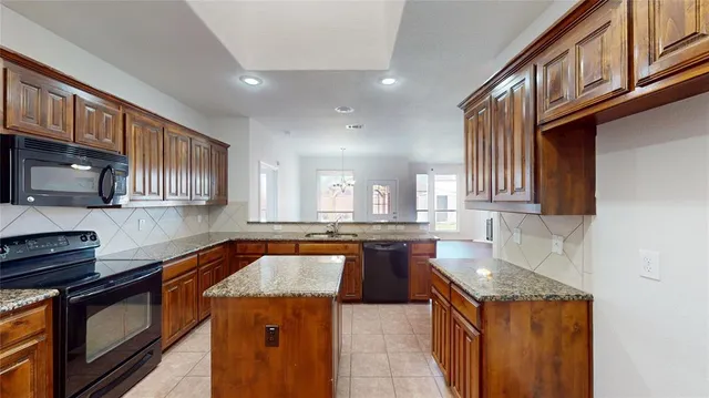 a kitchen with stainless steel appliances granite countertop a sink stove and cabinets
