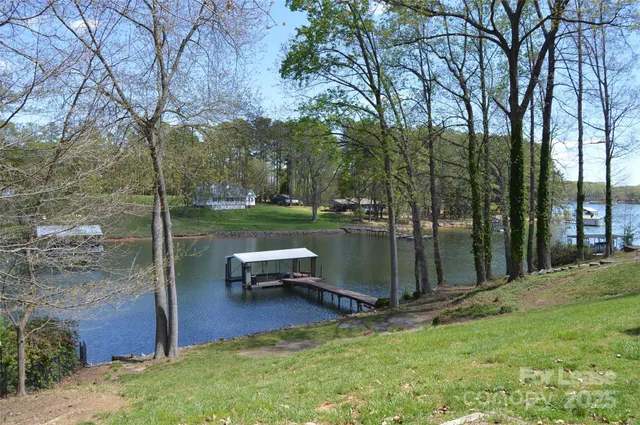 a view of a lake with a bench and trees