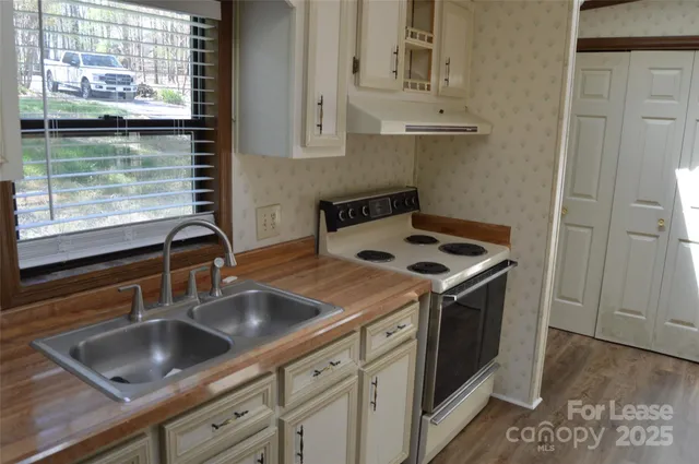a kitchen with sink a stove and cabinets