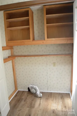 a view of a room with wooden floor and a window