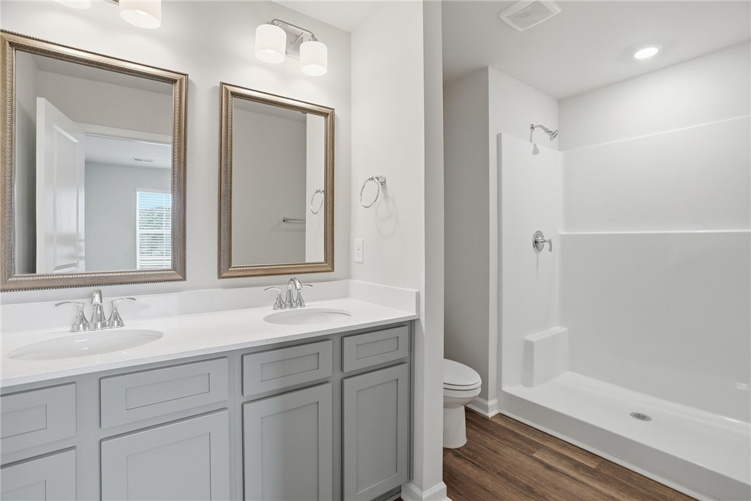 112 Lilac Loop Greenwood, SC 29649 - Photo 22 of 26 This clean and bright bathroom features dual vanities and a modern shower space.