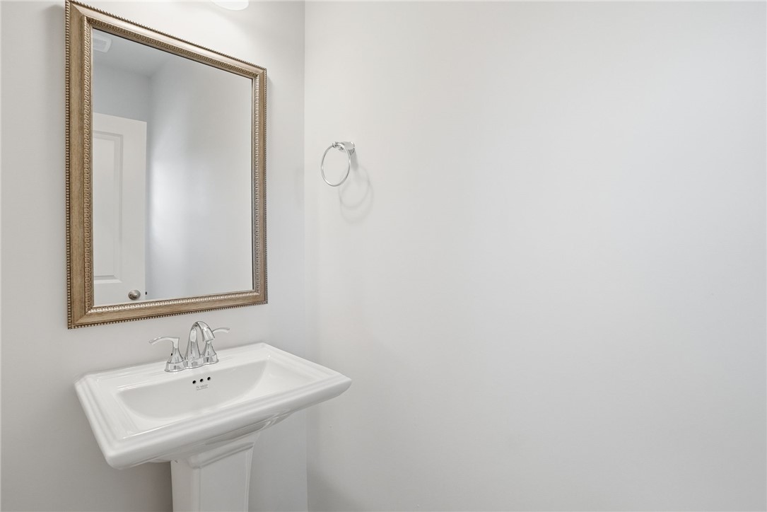112 Lilac Loop Greenwood, SC 29649 - Photo 6 of 26 This clean and inviting bathroom features a classic pedestal sink and a framed mirror.