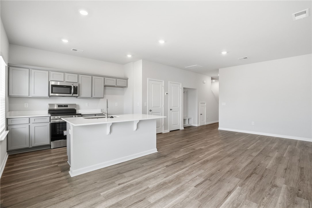 112 Lilac Loop Greenwood, SC 29649 - Photo 7 of 26 This spacious kitchen and living area feature modern amenities and durable flooring, ideal for everyday living.