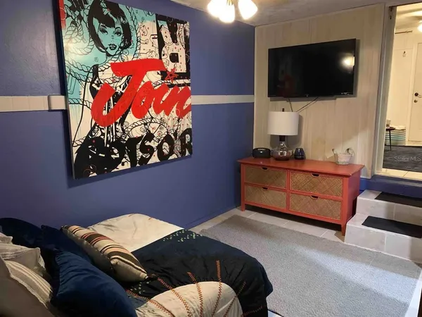 a bedroom with a bed and flat screen tv