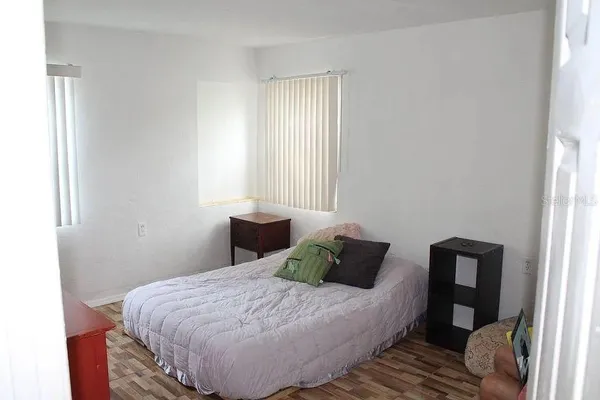 a bedroom with a bed and wooden floor