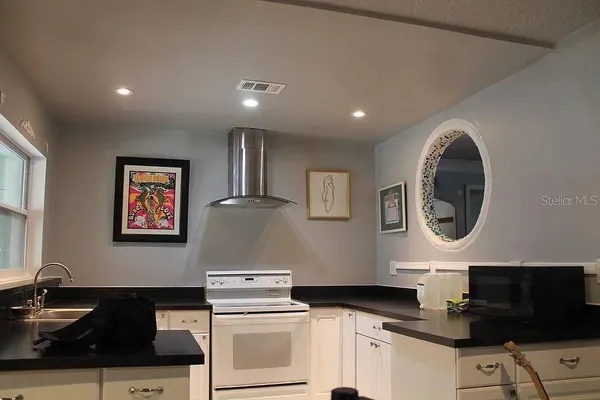 a kitchen with stainless steel appliances granite countertop a stove a sink a refrigerator and a microwave