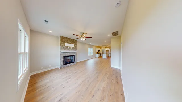 a view of a hallway with wooden floor and a kitchen