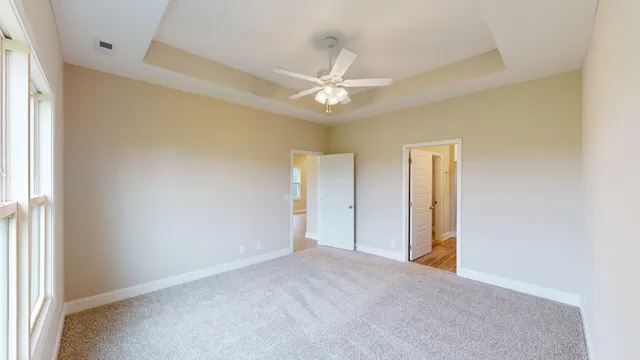 an empty room with a ceiling fan and a window