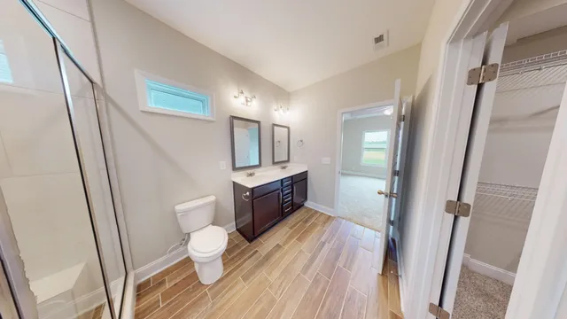 a bathroom with a sink a toilet a mirror and vanity