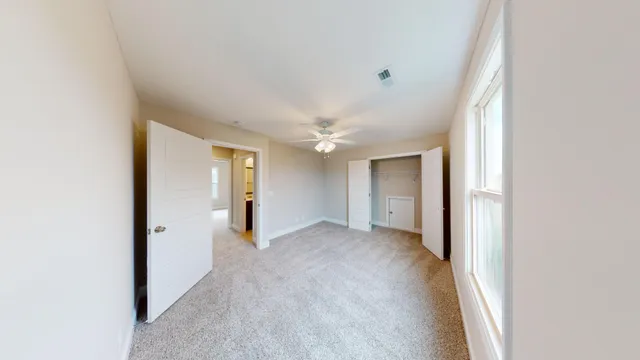 an empty room with an entryway and closet