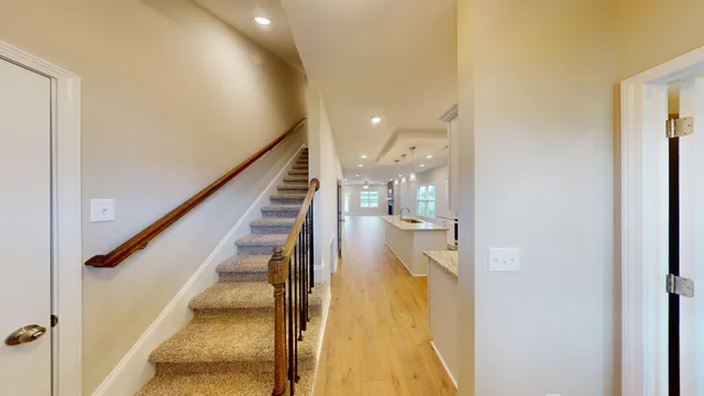a view of a hallway with wooden floor and staircase