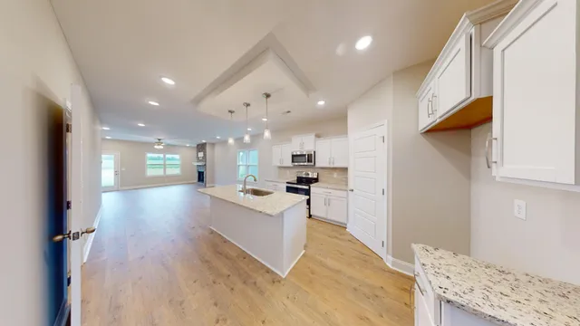 a view of kitchen with kitchen island wooden floor center island and stainless steel appliances