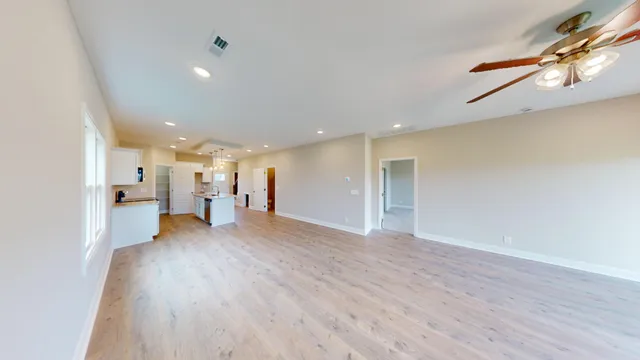 a view of a big room with wooden floor and a window