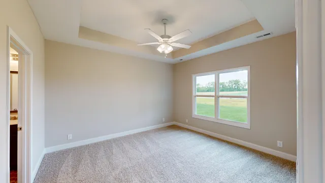 an empty room with a window and a fan