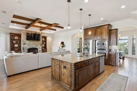 a kitchen with kitchen island a large counter top space a sink stainless steel appliances and cabinets