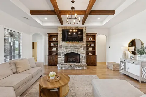 a living room with furniture a fireplace and a large window with garden view