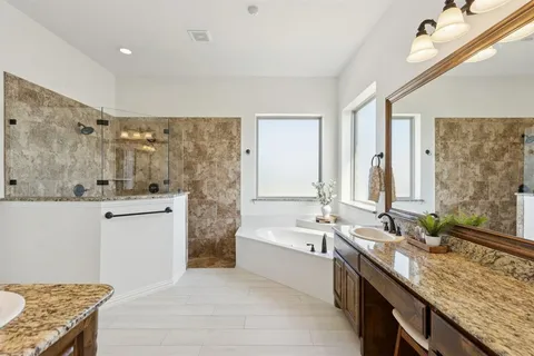 a spacious bathroom with a granite countertop tub sink and mirror