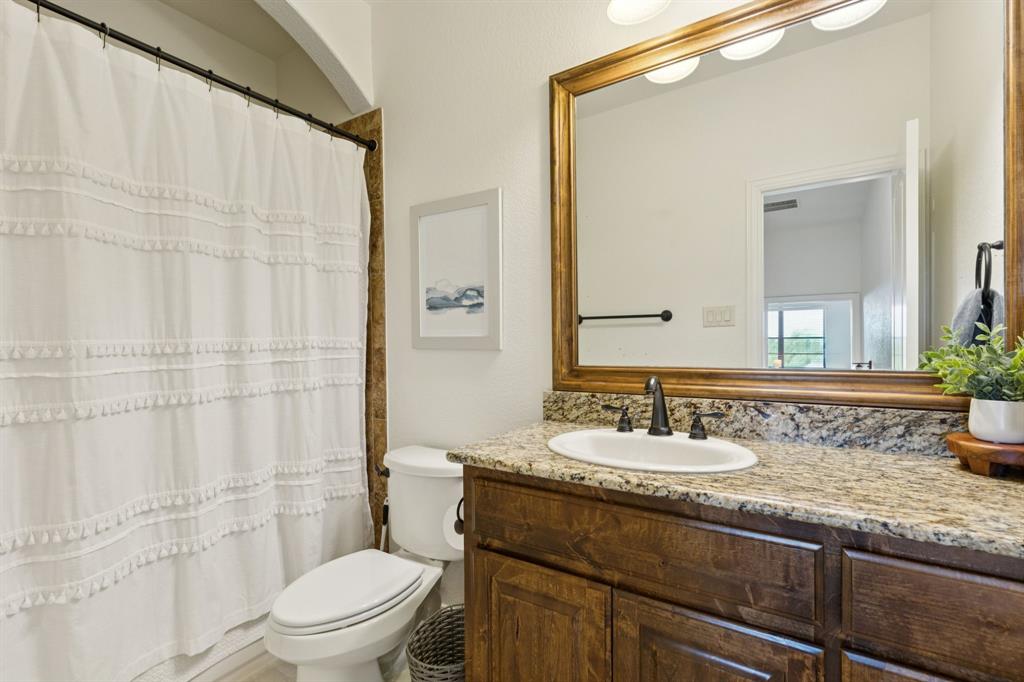 6824 Katie Corral Drive Fort Worth, TX 76126 - Photo 23 of 39 a bathroom with a granite countertop sink mirror vanity and toilet