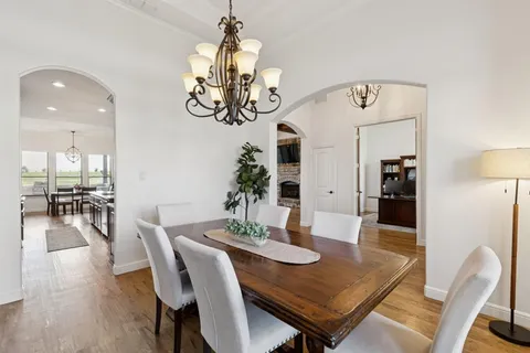a view of a dining room with furniture wooden floor and chandelier