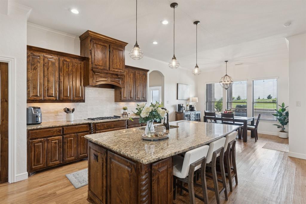 6824 Katie Corral Drive Fort Worth, TX 76126 - Photo 6 of 39 a kitchen with stainless steel appliances granite countertop a table chairs stove and kitchen island
