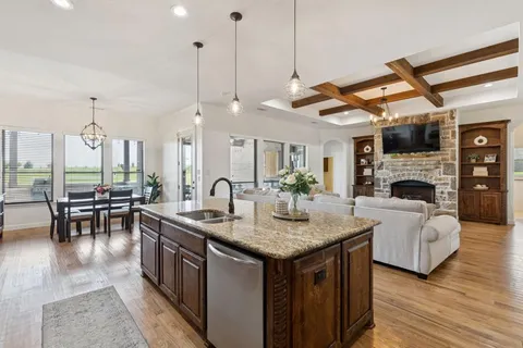 a kitchen with sink stove and living room view