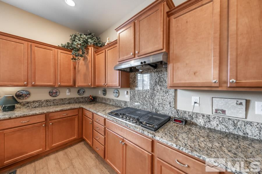 2210 Trakehner Lane Reno, NV 89521 - Photo 12 of 39 a kitchen with stainless steel appliances granite countertop a sink stove and cabinets