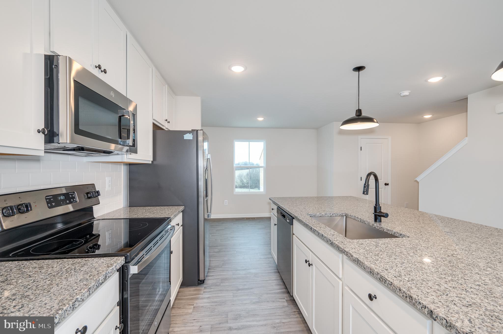 164 Rabbit Road Hedgesville, WV 25427 - Photo 26 of 41 a kitchen with stainless steel appliances granite countertop a sink a microwave a stove and a refrigerator