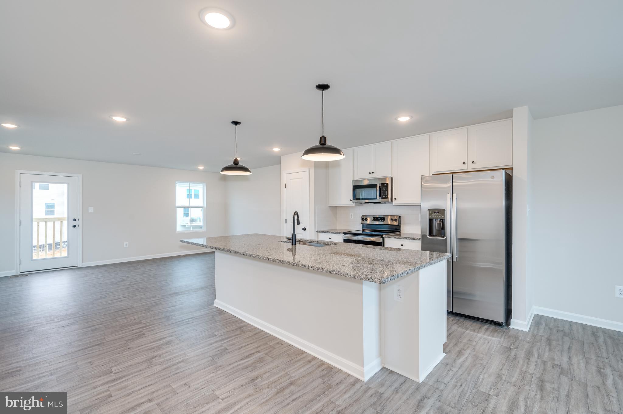 164 Rabbit Road Hedgesville, WV 25427 - Photo 28 of 41 a kitchen with stainless steel appliances granite countertop a refrigerator a sink dishwasher a stove and white countertops with wooden floor