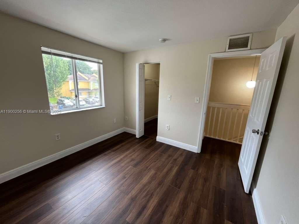 2271 Northwest 136th Terrace, Unit 2271 Opa-Locka, FL 33054 - Photo 15 of 23 a view of an empty room with wooden floor and a window