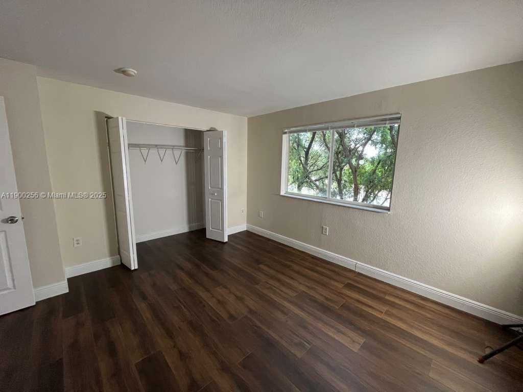 2271 Northwest 136th Terrace, Unit 2271 Opa-Locka, FL 33054 - Photo 18 of 23 a view of an empty room with wooden floor and a window