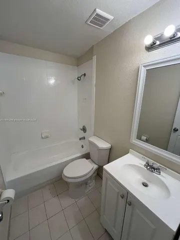 a bathroom with a sink toilet a mirror and bathtub