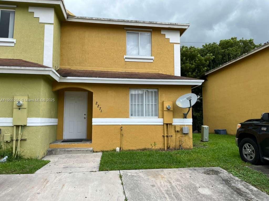 2271 Northwest 136th Terrace, Unit 2271 Opa-Locka, FL 33054 - Photo 2 of 23 a front view of a house with a garden and parking