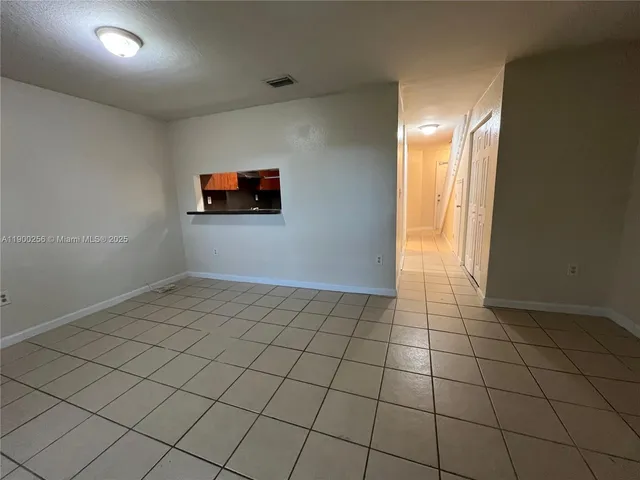 an empty room with windows and couch