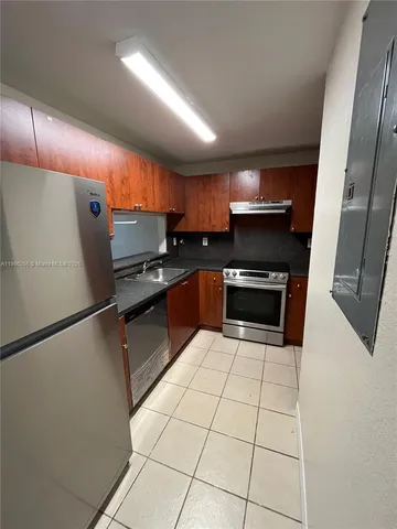a kitchen with granite countertop a refrigerator and a sink