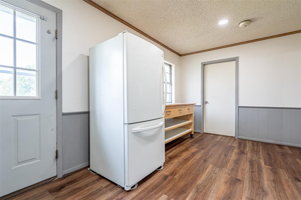 501 Endora Dublin, TX 76446 - Photo 17 of 39 a kitchen with a refrigerator and wooden floor