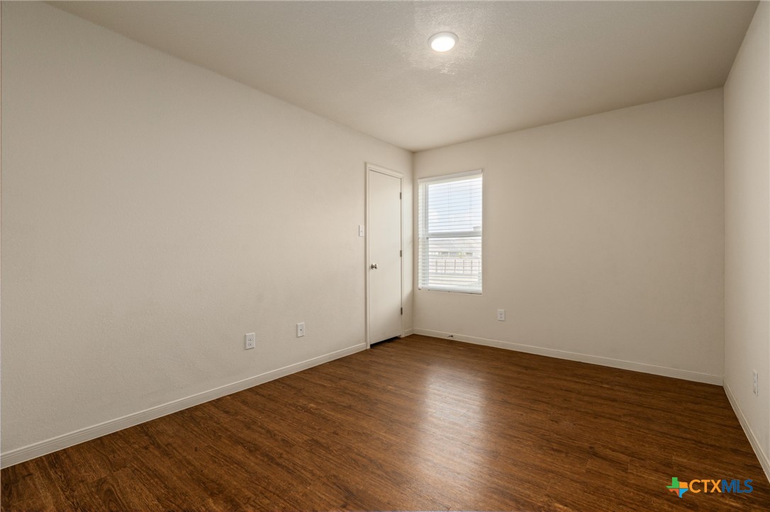 5701 Rustler Drive, Unit B Killeen, TX 76543 - Photo 14 of 29 a view of an empty room with wooden floor and a window