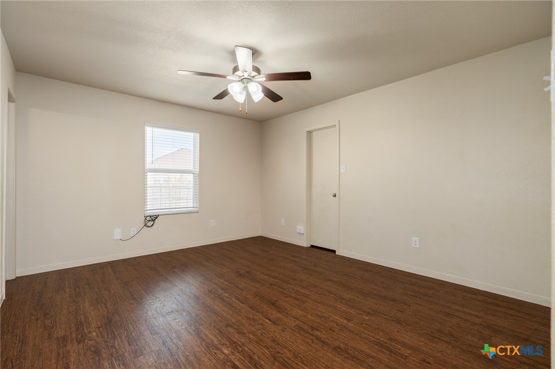 5701 Rustler Drive, Unit B Killeen, TX 76543 - Photo 18 of 29 an empty room with wooden floor fan and windows