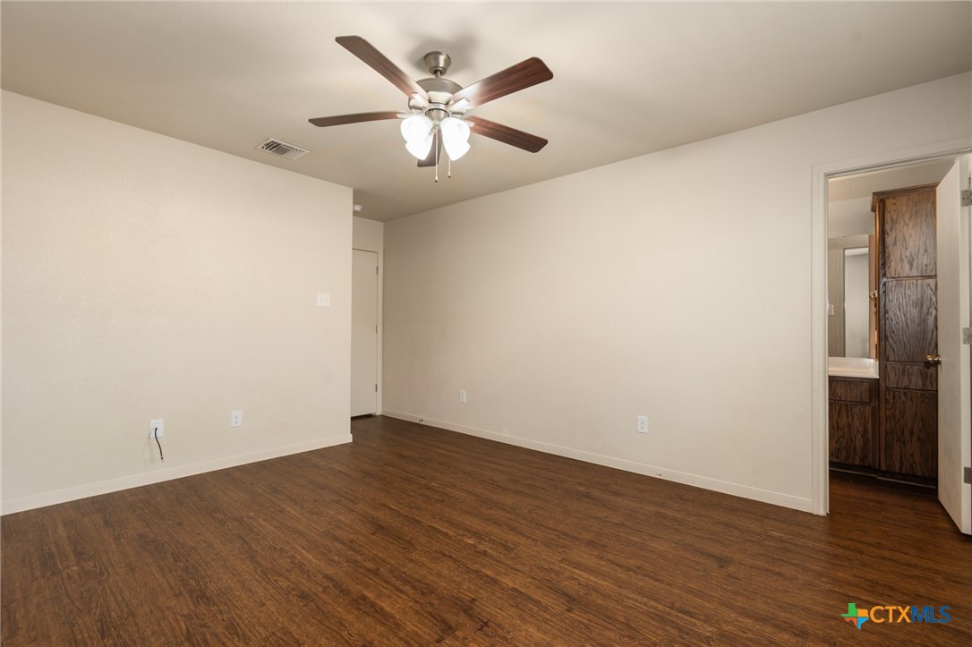 5701 Rustler Drive, Unit B Killeen, TX 76543 - Photo 19 of 29 an empty room with wooden floor and windows