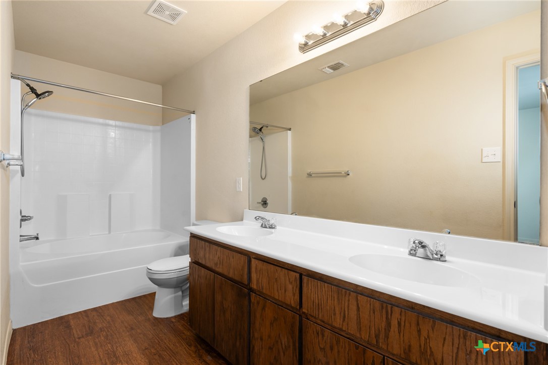 5701 Rustler Drive, Unit B Killeen, TX 76543 - Photo 20 of 29 a bathroom with a bathtub shower sink vanity and toilet
