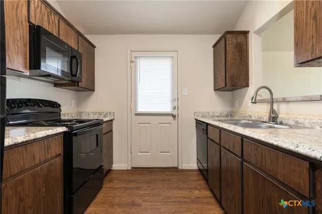 a kitchen with stainless steel appliances granite countertop a sink stove and microwave