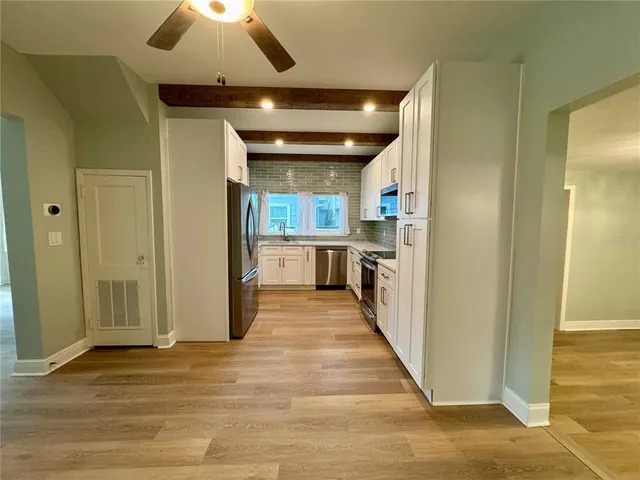 a view of a hallway with wooden floor