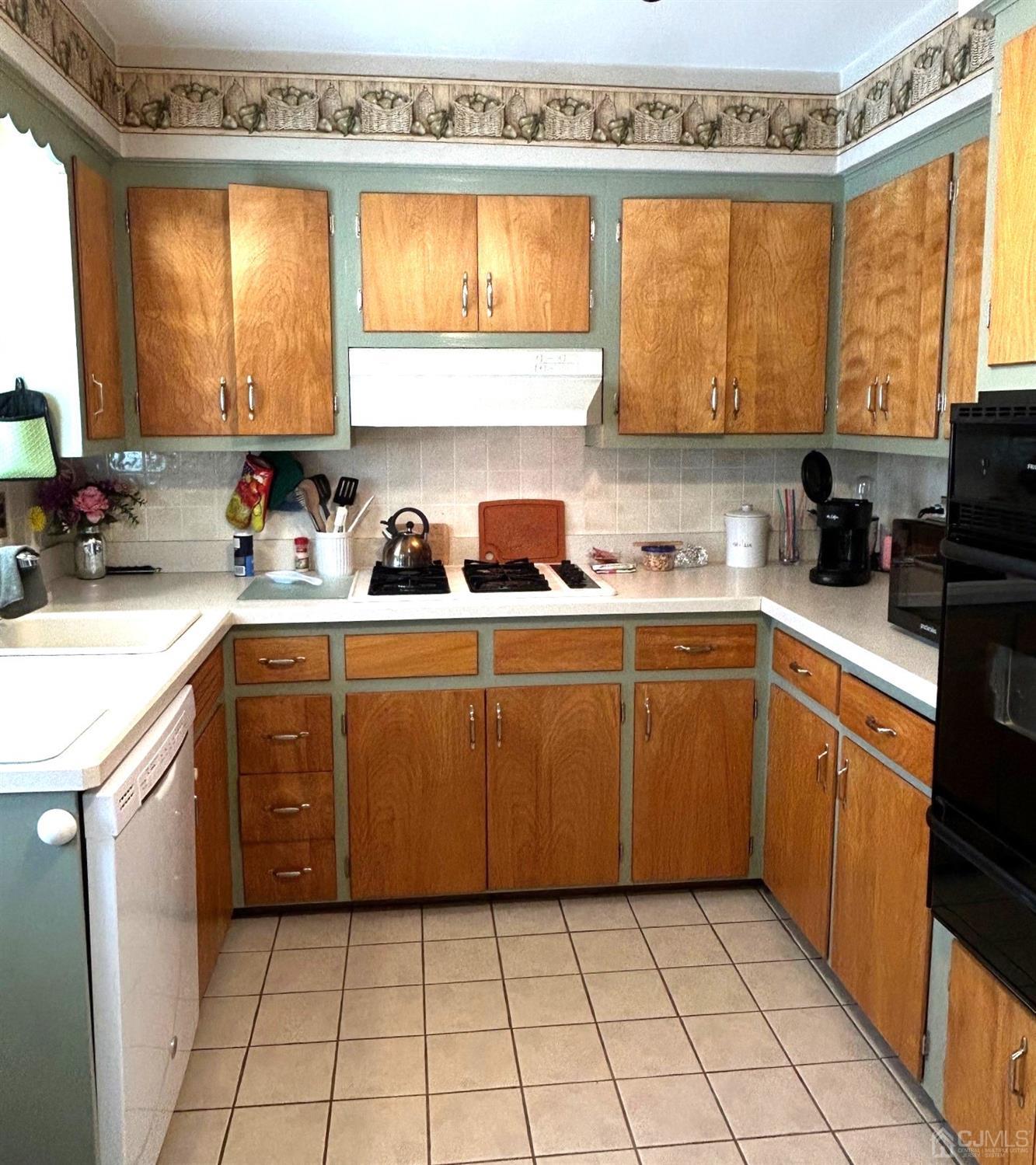 327 New Market Road Dunellen, NJ 08812 - Photo 8 of 13 a kitchen with a sink a stove a counter top space and cabinets