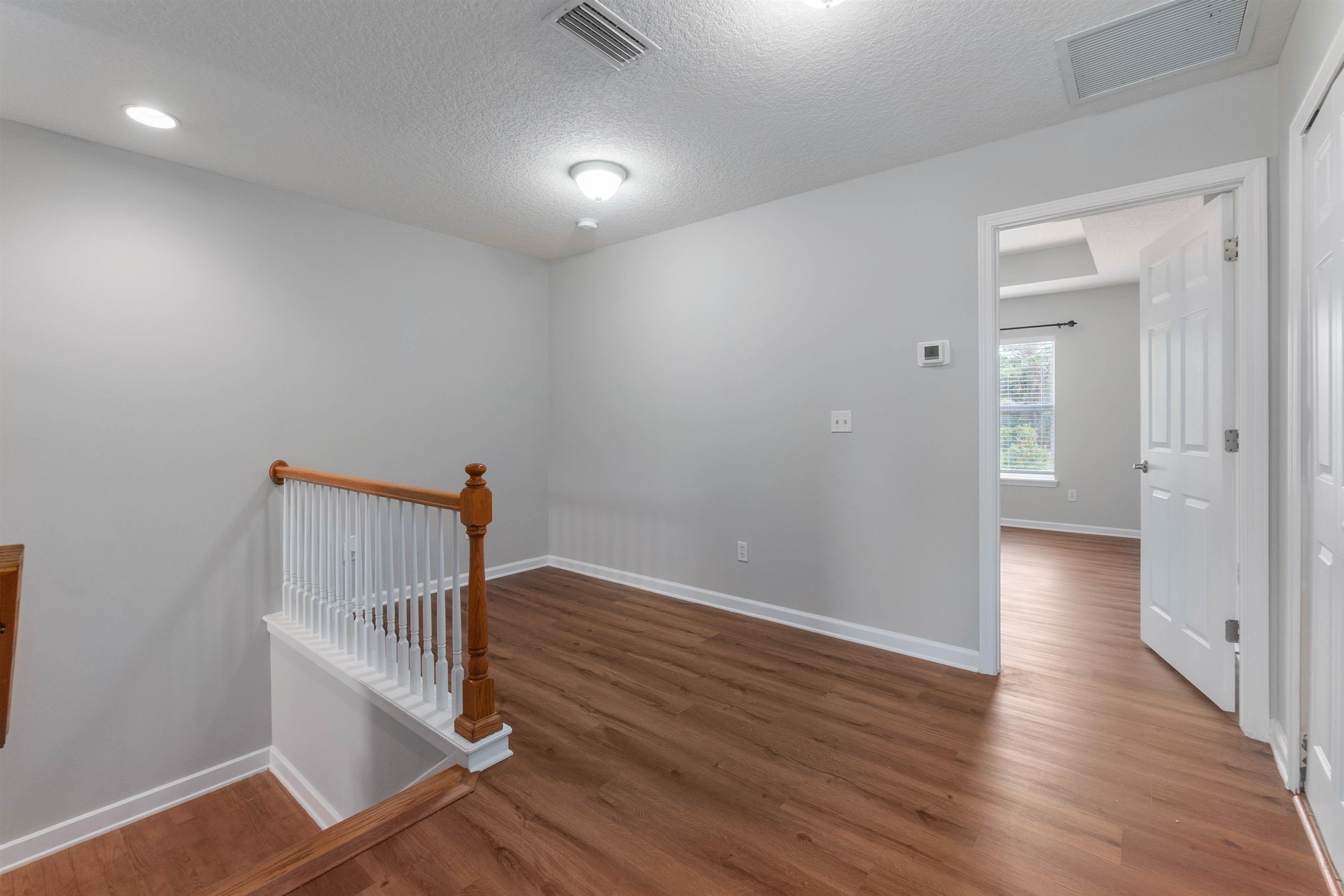 18 Amistad Drive St. Augustine, FL 32086 - Photo 13 of 37 wooden floor in an empty room with a window
