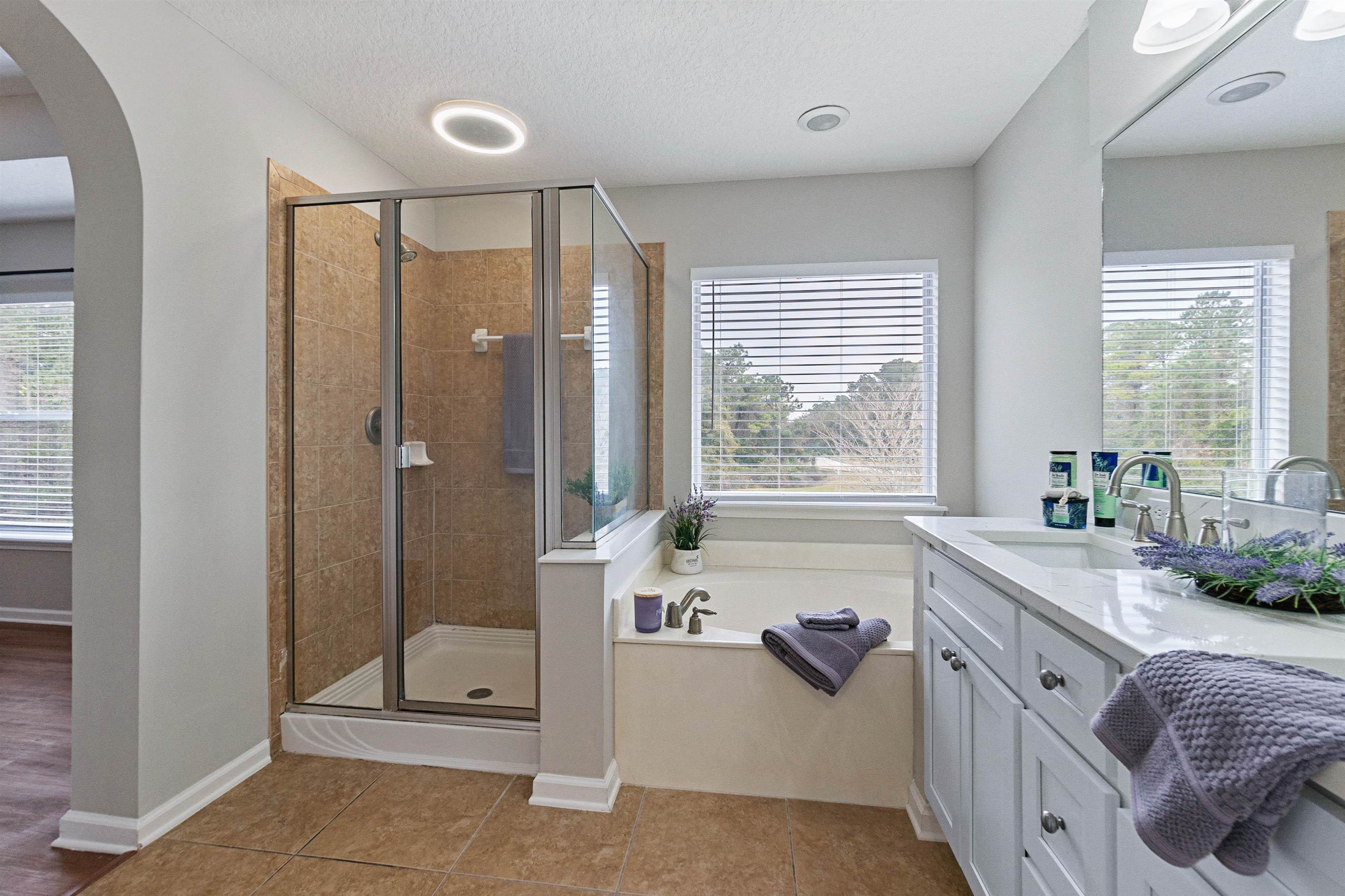 18 Amistad Drive St. Augustine, FL 32086 - Photo 23 of 37 a bathroom with a granite countertop tub sink a window and a shower