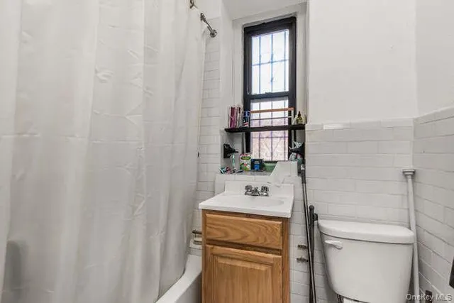 a bathroom with a toilet sink vanity and mirror
