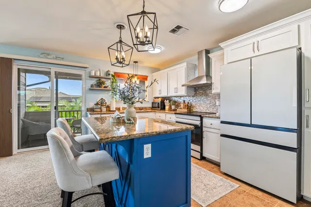 a kitchen with stainless steel appliances granite countertop a sink a stove and a refrigerator