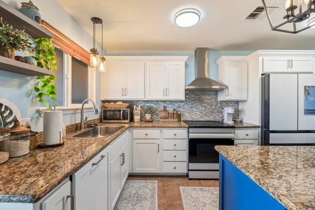 a kitchen with stainless steel appliances granite countertop a sink stove and refrigerator
